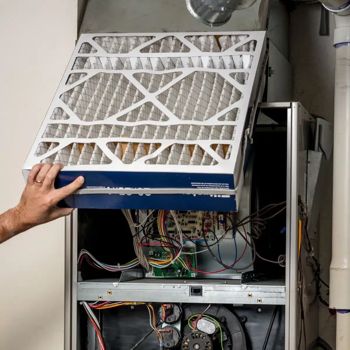 a technician changing the furnace air filter.