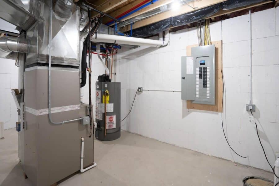 A photo of a furnace and electrical box in a basement.