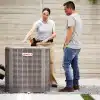 An HVAC specialist introducing an outdoor AC unit to a homeowner.